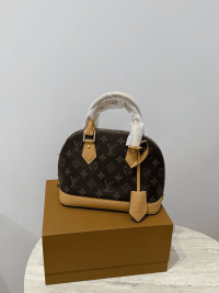 Louis Vuitton Alma Medium handbag on display box.
