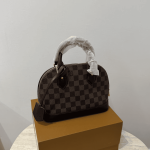 Louis Vuitton Alma Medium handbag on box, checkered pattern.