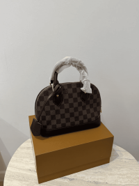 Louis Vuitton Alma Medium handbag on box, checkered pattern.
