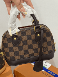 Louis Vuitton Alma Mini handbag with checkered design and gold accents.