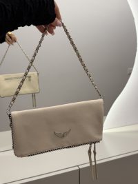 Elegant Zadig & Voltaire beige handbag with chain strap and wing emblem.