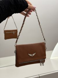 Brown leather handbag with chain strap, wing emblem, elegant design.