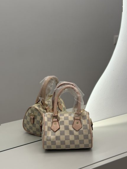 Louis Vuitton Speedy Damier Azur handbag on mirrored surface.