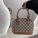 Louis Vuitton Nano Speedy handbag with checkered pattern and leather accents.
