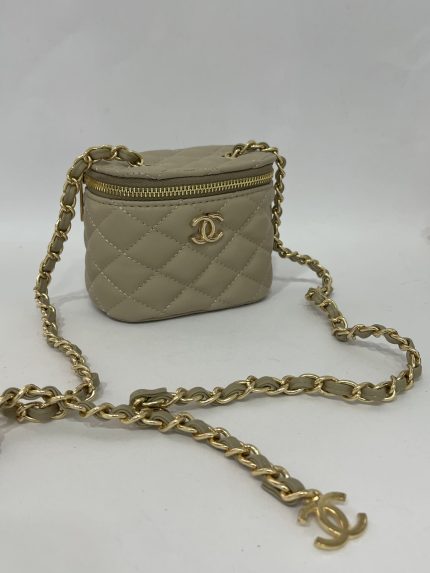 Elegant beige quilted mini Chanel bag with gold chain strap.