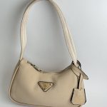 Prada Re-Edition Mini beige handbag with logo and strap.