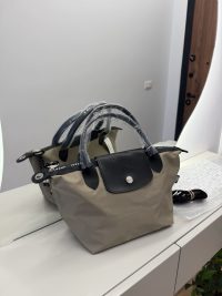 Beige Longchamp Le Pliage Cuir handbag with black leather accents.