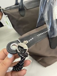 Canta Longchamp Le Pliage Cuir handbag with leather handles and logo.