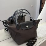 Canta Longchamp Le Pliage Cuir handbag on display with strap.