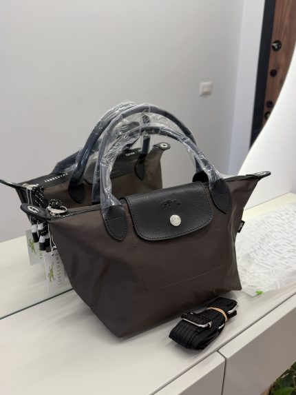 Canta Longchamp Le Pliage Cuir handbag on display with strap.