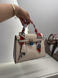 Hermes Kelly Mini handbag with colorful scarf handle detail.