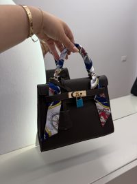 Hermes Kelly Mini handbag with colorful handle scarf, luxury fashion accessory.