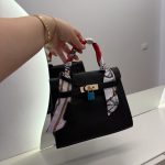 Black Hermes Kelly Mini handbag with colorful handle scarf.