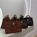 Hermes Birkin Tote bags in brown and black on display.