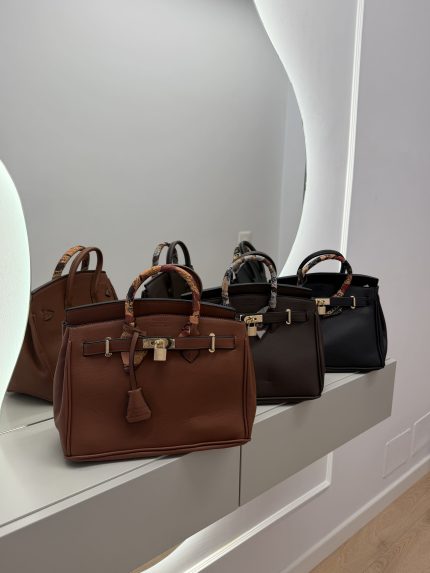 Hermes Birkin Tote bags in brown and black on display.