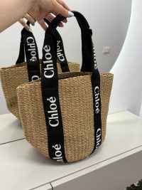 Chloe woven beach bag with black logo straps.