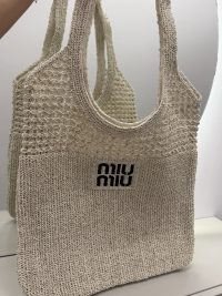 Beige Miu Miu beach bag with textured knit design.