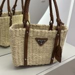 Prada straw tote with leather handles, perfect beach bag.