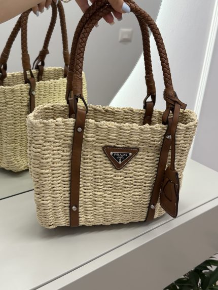 Prada straw tote with leather handles, perfect beach bag.
