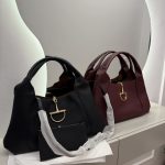 Canta Gucci Horsebit Hobo bags in black and burgundy on display.
