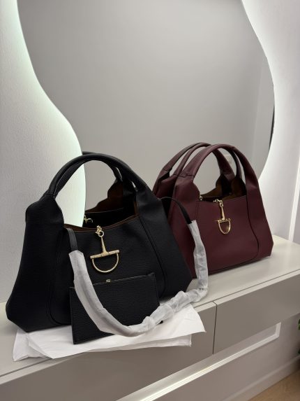 Canta Gucci Horsebit Hobo bags in black and burgundy on display.