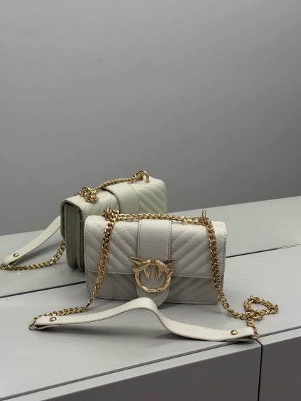 Elegant Çanta Pinko bag with gold chain and bird emblem.