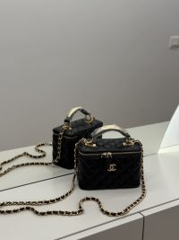 Çanta Vanity Chanel për Femra, black quilted handbag with gold chain.