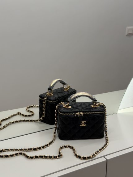 Çanta Vanity Chanel për Femra, black quilted handbag with gold chain.