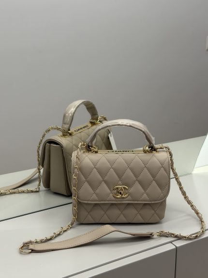 Beige Chanel Flap Bag with gold chain and logo.