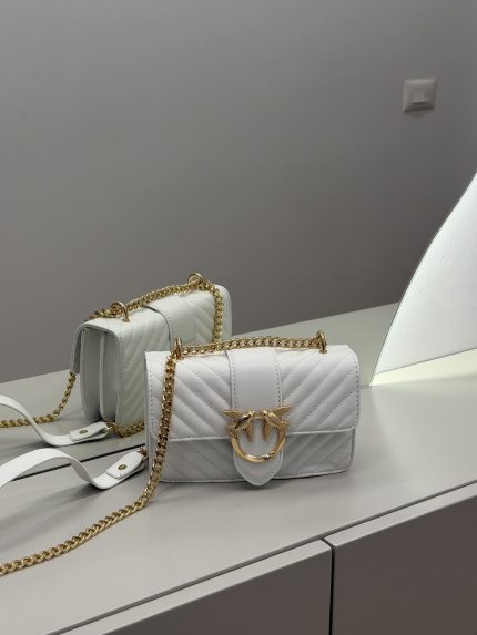Elegant white handbag with gold chain and bird emblem.