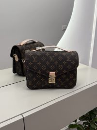 Louis Vuitton Pochette Metis handbag on mirrored surface.