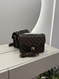 Louis Vuitton Pochette Metis handbag on mirrored surface.