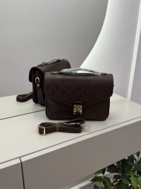 Louis Vuitton Pochette Metis handbag on mirrored surface.