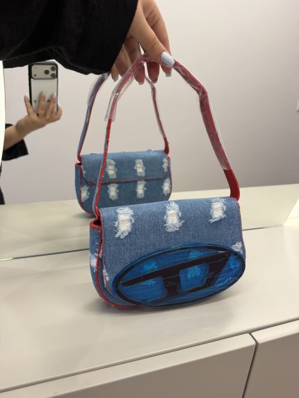 Diesel 1DR women's denim handbag with red strap in mirror reflection.