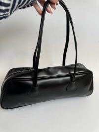 Black boxy handbag with zipper and long handles for women.