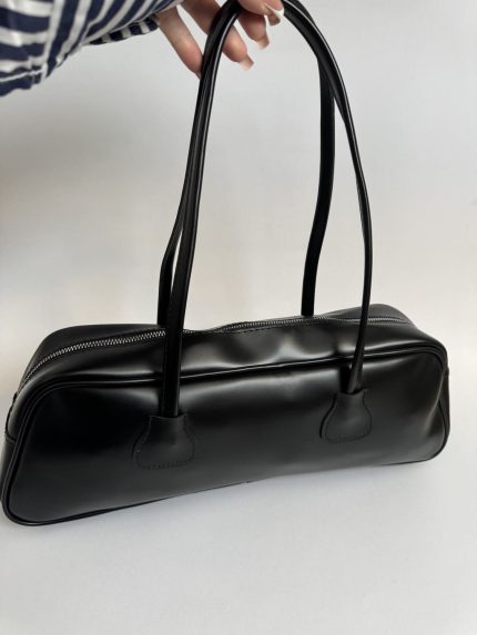 Black boxy handbag with zipper and long handles for women.