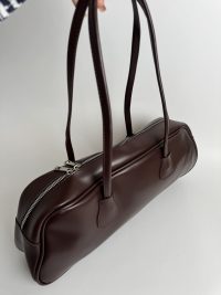 Brown boxy women's handbag with zipper and long handles.