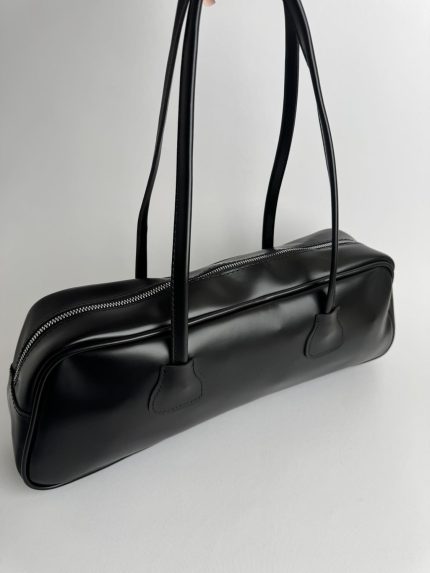 Black boxy women's handbag with zipper and long handles.