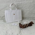 Structured white handbag with leopard print scarf accessory.