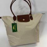 Çanta Longchamp Le Pliage XL cream tote with brown leather handles.