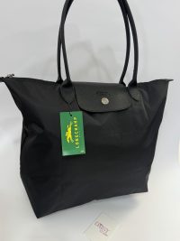 Black Longchamp Le Pliage XL tote bag with handles.