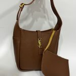 Brown structured handbag with scarf and gold accents.