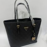 Black Michael Kors tote bag with embossed pattern and gold accents.