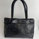 Black crocodile-pattern university handbag with handles.