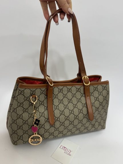 Gucci GG monogram handbag with red lining and brown leather handles.