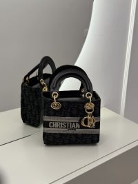 Christian Dior small handbag with logo, elegant design on mirror surface.