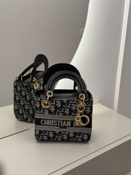 Christian Dior small handbag, elegant black and gold design.