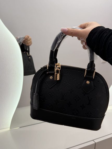 Black Louis Vuitton Alma BB handbag with monogram pattern.