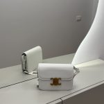 White Celine mini bag on mirrored surface, elegant and stylish design.