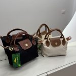 Longchamp Le Pliage Small bags in black and beige on display.